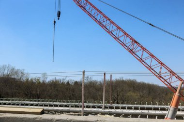 İnşaat işçileri, beton köprü yenileme sırasında malzeme kaldırmak için vinç kullanıyor