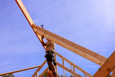 Kaliteli inşaat işçisi montaj çalışmaları altında binanın çatısına kirişleri güvence altına alıyor