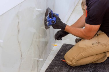 Yetenekli işçiler duvarlara dikkatlice fayans döşeyerek, çağdaş ayarlarda doğruluk kalitesini sağlarlar.