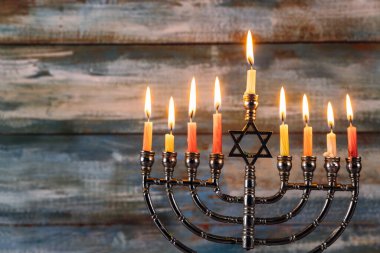 Menorah yanan mumlarla ayakta duruyor, Hannuka kutlamasında sıcak ışık tutuyor. Yahudi şenliği sırasında.