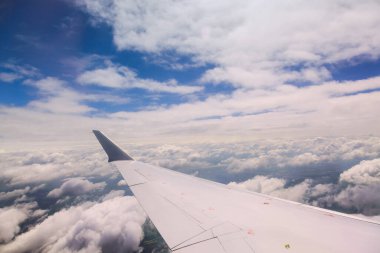 Tüylü bulutların canlı mavi gökyüzünün yolculuk sırasında uçak kanadından görünüşü.