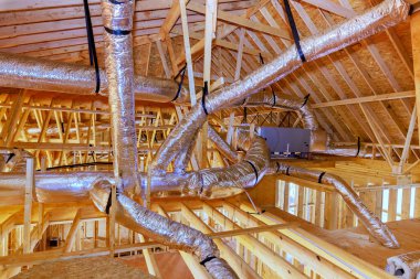 İşçiler yapım aşamasındaki binanın tavanına ahşap kirişlerle yalıtım malzemesi döşüyorlar.