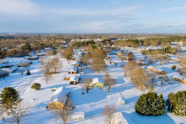 Kar, Amerikan köyünün huzurlu banliyö bölgesindeki ağaçları kaplayarak sakin bir kış manzarası yaratıyor.