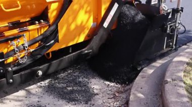14 Ekim 2025 New York Amerikan Paving makinesi asfalt döşedi. Kamyon, yol bakımı için sıcak asfalt boşaltıyor.