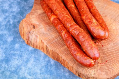 Ev yapımı sosisler ahşap tahtada oturur, mutfakta yemek servisi için hazırlanırlar..