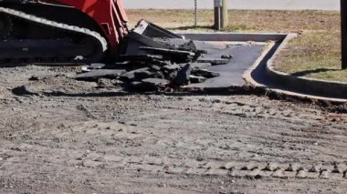 Ağır makineler, kırık asfalt parçalarını inşaat alanından kaldırıyor