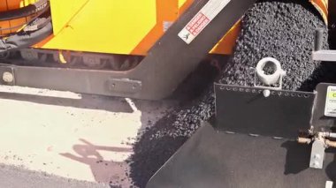 Taze asfalt kentsel gelişim üzerine yol yapım kaldırım makinesiyle döşeniyor.