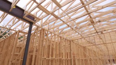 İşçiler yerleşim bölgesinde çeşitli metal destekleriyle ahşap kirişler yapı inşa ediyorlar.