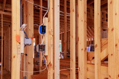 İşçiler, inşa edilen ahşap çerçeveler içinde elektrik sistemleri kuruyorlar.