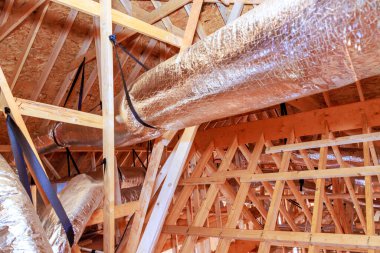 İşçiler inşa edilen binanın tavanına metal kanal döşüyorlar.