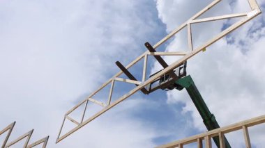 Çatı montajı sırasında yapı iskeleti inşa etmek için tahta kirişleri kaldırır