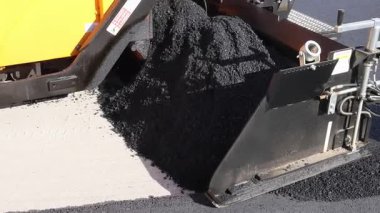 Makineler yola yeni asfalt sererken işçiler yüzeyi hazırlıyorlar