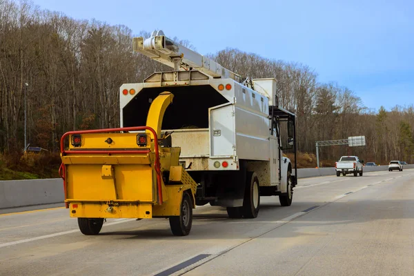 Kamyon, Amerikan kırsal kesiminde birkaç araçla otoyolda sarı römork çekiyor.