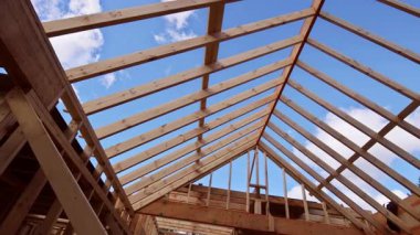 İşçiler ahşap kirişler çatı iskeleti kirişleri ile yapı iskeleti inşa ediyorlar