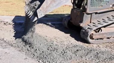 Kazıcı yol bakımına hazırlanmak için inşaat sahasına çakıl döker.