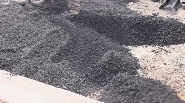 14 Ekim 2025. New York ABD 'de birçok işçi yol yapım alanındaki otoyol bakımında taze asfalt yaymak için kürek kullanıyor.