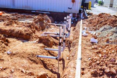 İşçiler, çalışma sahasına inşaat projesine boru döşemek için hendek kazıyorlar.