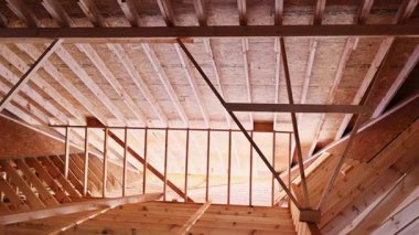 Ahşap işçileri yeni inşa edilmiş binanın içinde çatı kirişlerini birleştiriyorlar.