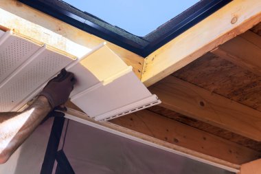 İşçi inşaat halindeyken tavandaki fasya panelini içeride tutuyor