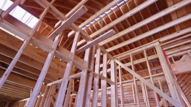 İşçiler çerçeve yoluyla yeni bina için ahşap kirişler monte ediyorlar.