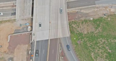 İnşaat işlerinde kavşakta farklı yollarda giden araçlar yan yana, bölgede toprak görülüyor.