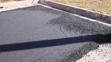 İşçiler otoyol bakımı sırasında çevredeki yol yüzeyine taze asfalt uyguluyorlar