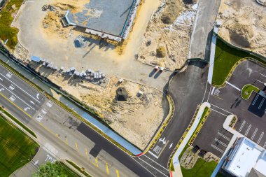 Yeni binalar etkin trafiğin olduğu yol kenarında şekillenirken, işçiler inşaat alanında meşgul.