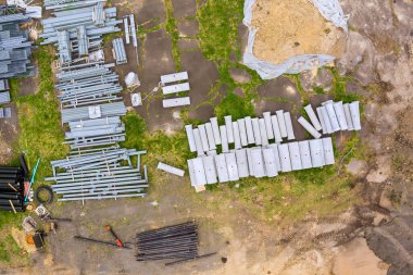 Metal kiriş boruları inşaat sahasında çimenlik toprakla birlikte yerleştirilmiş.