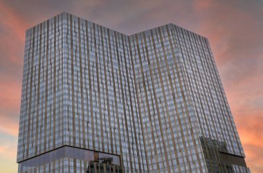 Gün batımında şehirde uzun cam bina duruyor. Las Vegas 'ın keskin açıları var.