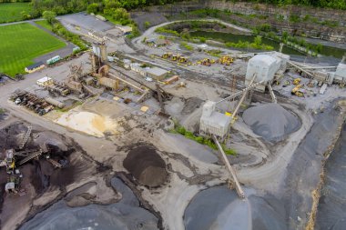 Taş ocağındaki işlek inşaat alanından makine ve toprak kaya yığınlarının görüntüsü.