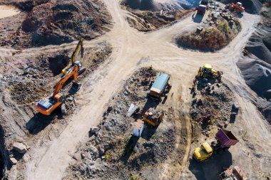 İnşaat sahasında ağır makineler çalışıyor. Çakıl taşlarını ilerisi için hazırlıyorlar..