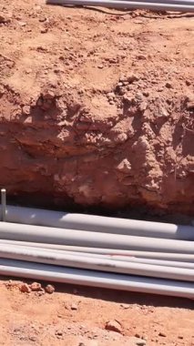 İşçiler, toprak altında borularla dolu bir siper hazırlıyorlar..