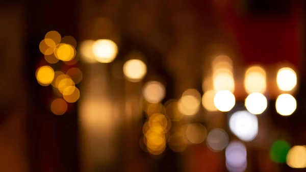 カフェレストランの近くの外で抽象的な夜輝くボケの背景効果 都市部の生活の妨げ黄金の電球花輪花輪をぼかす クリスマス ニューイヤーパーティーのコンセプト — ストック写真