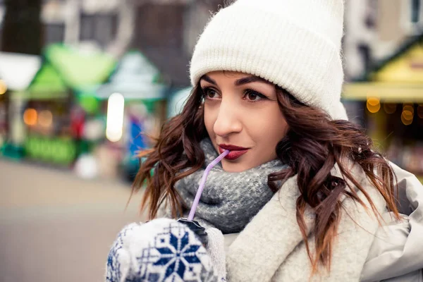 若い美しい女性の通りに立ってカラフルなプラスチックチューブルホットティー飲料コーヒーチョコレートを飲む 外で時間を過ごす 新年のクリスマスの装飾 バレンタインデーのコンセプト — ストック写真