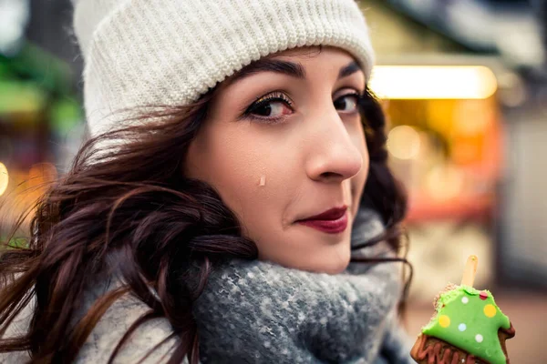 사랑스럽고 아름다운 여자가 길거리에서 눈물을 흘리며 초콜릿 쿠키를 막대기 위에서 — 스톡 사진