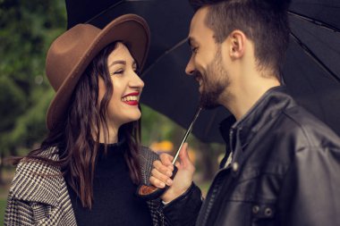 Şehir parkında yürüyen ve yağmuru korumak için şemsiye kullanan genç bir çiftin portresi. Heteroseksüel aşıkların randevusu vardır. Bulutlu yağmurlu bir günde birlikte vakit geçirirler. Duygularını gösterirler..