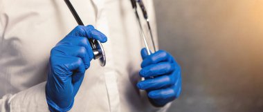 Doktor hemşire hasta kişisel koruyucu ekipman. Sağlık sigortası konsepti. Beyaz gömlekli, mavi maskeli sterilize eldivenli bir adam. Koronavirüs salgını. Boynunda steteskop var.