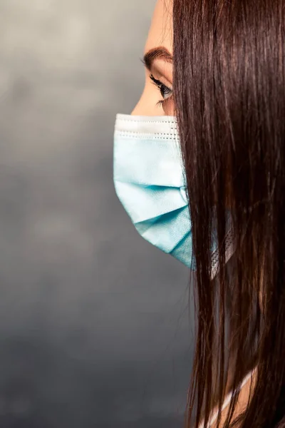 Vertical portrait of doctor nurse patient personal protective equipment. Healthcare concept. Woman wear white gown uniform, blue face disposable mask. Coronavirus pandemic.