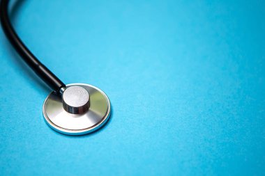 Siyah modern steteskopu mavi arkaplanda yansıması olan ve mesaj için kopyasız alan olan kapatıyoruz. Tıbbi hemşire ya da doktor ekipmanı objesi. Tıp sağlık hizmetleri kavramı.