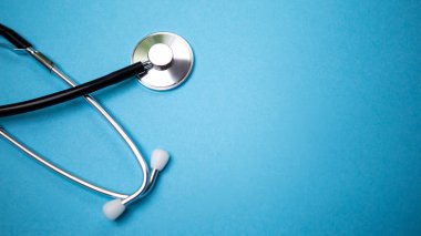 Siyah modern steteskopu mavi arkaplanda yansıması olan ve mesaj için kopyasız alan olan kapatıyoruz. Tıbbi hemşire ya da doktor ekipmanı objesi. Tıp sağlık hizmetleri kavramı.