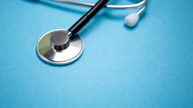 Siyah modern steteskopu mavi arkaplanda yansıması olan ve mesaj için kopyasız alan olan kapatıyoruz. Tıbbi hemşire ya da doktor ekipmanı objesi. Tıp sağlık hizmetleri kavramı.