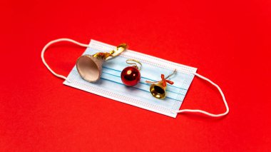 Mavi maskeler ve yılbaşı ağacı Noel oyuncakları izole edilmiş kırmızı arka plan. Sağlık sigortası. Korunma enfeksiyonu önler, koronavirüse karşı hastalık, mevsimsel grip. 