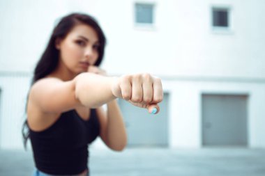 Senden nefret ediyorum. Yumruğu havada genç ve güzel bir kadının portresi kötü ruh hali skandalıyla dolu. Dışarıda dikilen siyah cüppeli öfkeyi hisset. Kopyalama alanı olan resim.