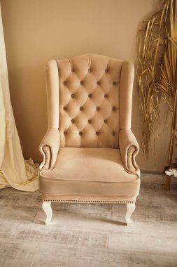 Stüdyoda kır çiçeklerinden yapılmış düğün fotoğrafları. Fotoğraf çekimi için uygun bir yer. Büyük yumuşak kahverengi sandalye dekorasyonu, kopyalama alanı.