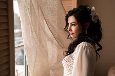 Wife at the photo session in studio. Married bride celebrate engagement. Procreation romantic amazing woman indoor, copy space. Prepating for wedding day, fees looking at the window