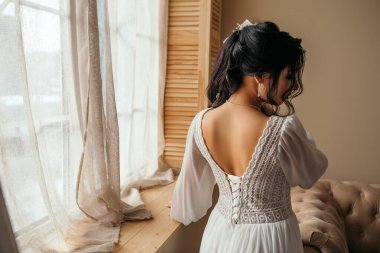 Wife at the photo session in studio. Married bride celebrate engagement. Procreation romantic amazing woman indoor, copy space. Prepating for wedding day corset dressing fees, fasten dress