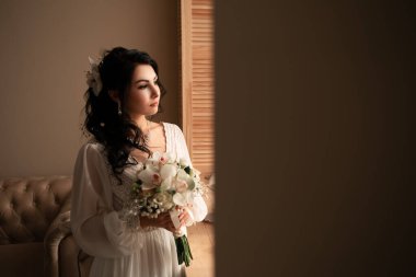 Wife at the photo session in studio. Married bride celebrate engagement. Procreation romantic amazing woman indoor, copy space. Prepating for wedding day, holding bridal bouquet fees