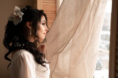 Wife at the photo session in studio. Married bride celebrate engagement. Procreation romantic amazing woman indoor, copy space. Prepating for wedding day, fees looking at the window