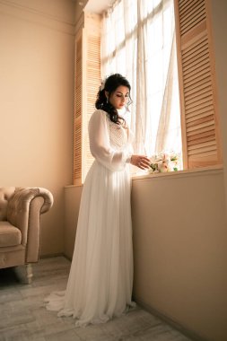 Wife at the photo session in studio. Married bride celebrate engagement. Procreation romantic amazing woman indoor, copy space. Prepating for wedding day, holding bridal bouquet fees