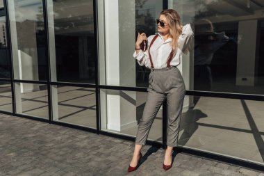 Camdan gökdelenin yanında duran zarif bayan avukatla dolu uzun bir çekim. Küçük işletme sahibi kavramı. Hırsla dolu serbest çalışan büyük bir şirket kurmak istiyor..